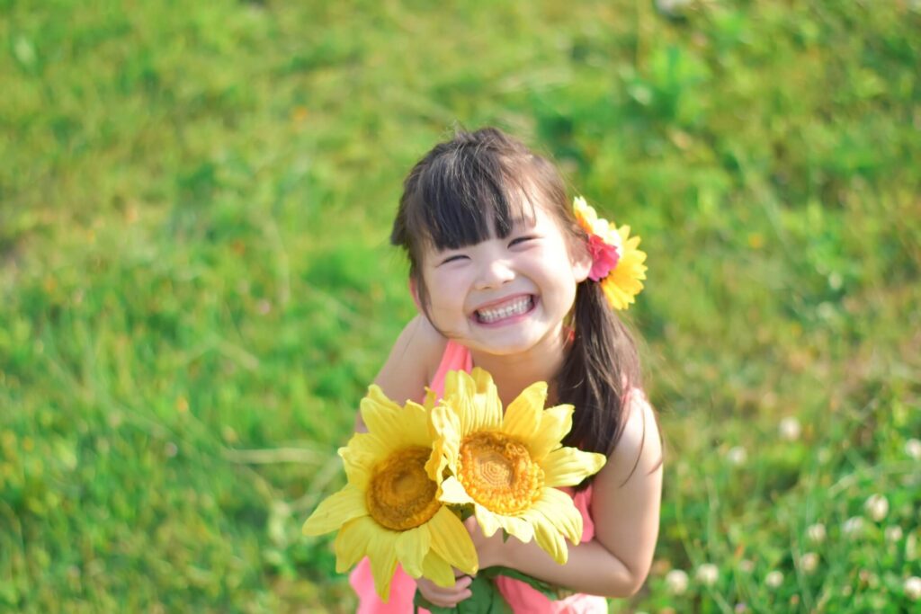 お花畑で幸せそうに笑う女の子