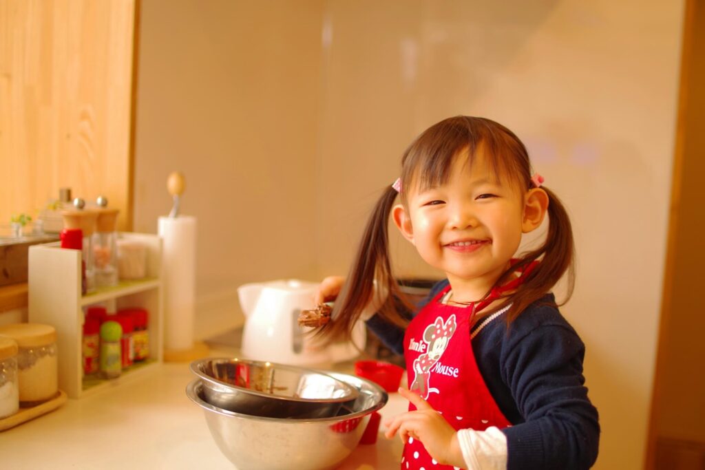 キッチンで楽しく料理する幼い子