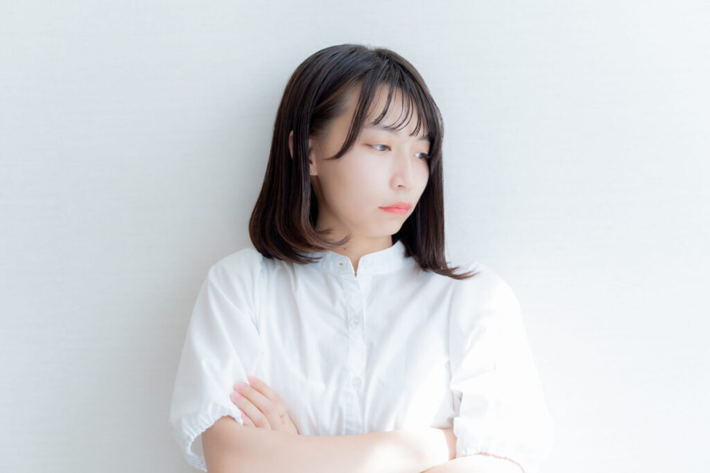 腕組みして悩む女性