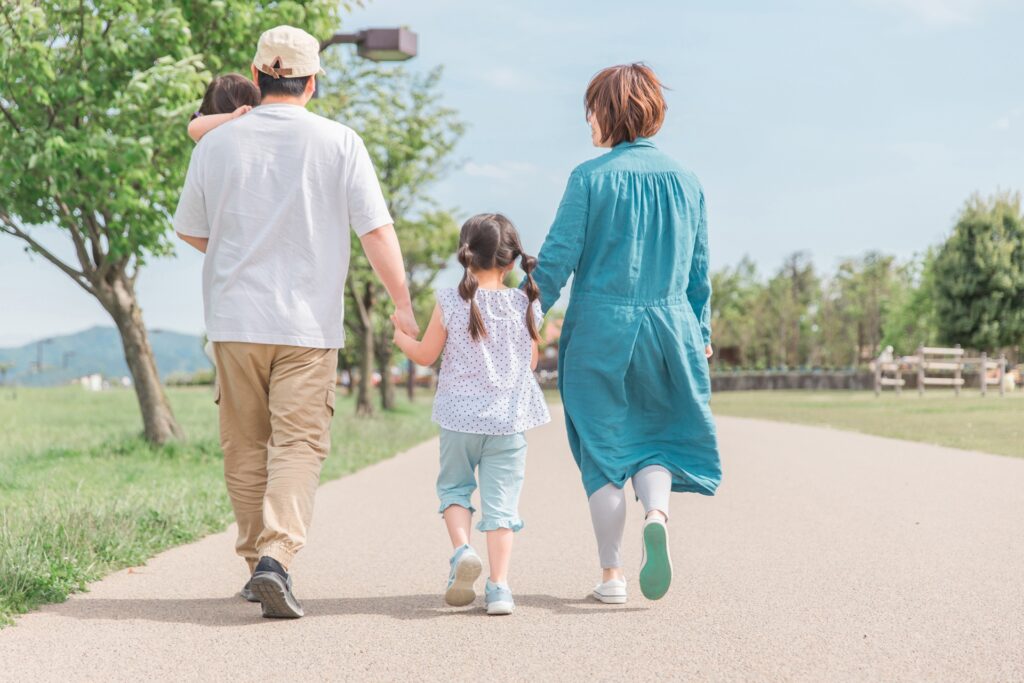 家族が一緒に歩いていく後ろ姿