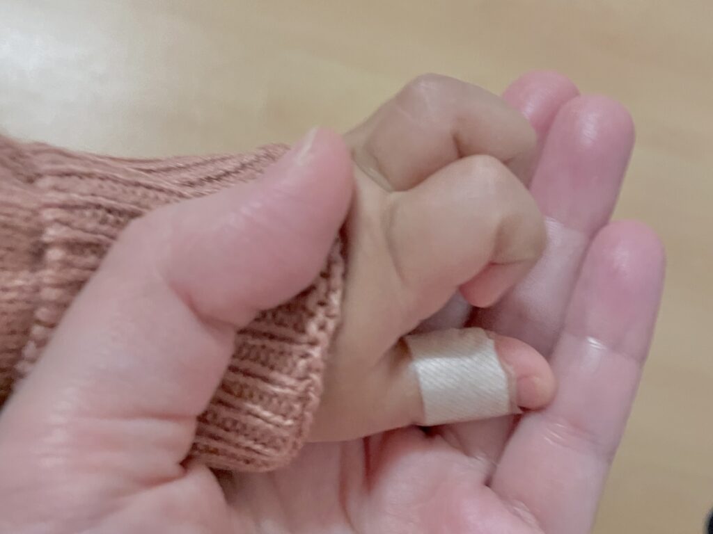 赤ちゃんの手を包み込むママの手
