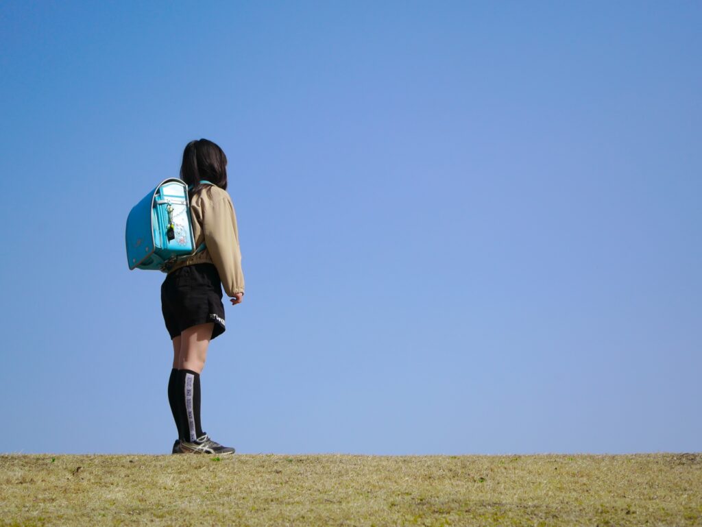 青空を見上げる小学生の女の子