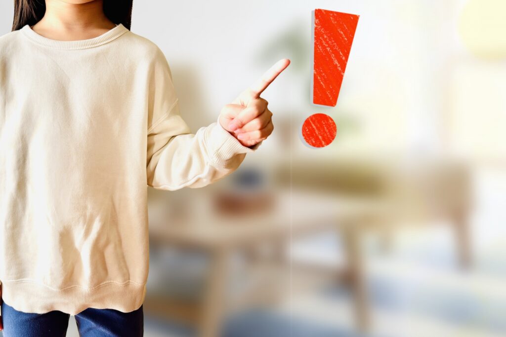 ビックリマークを指さす女性